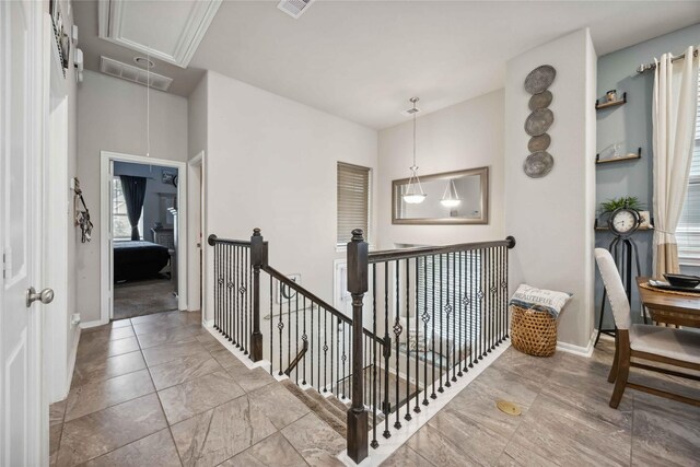hallway featuring attic access, baseboards, and an upstairs landing