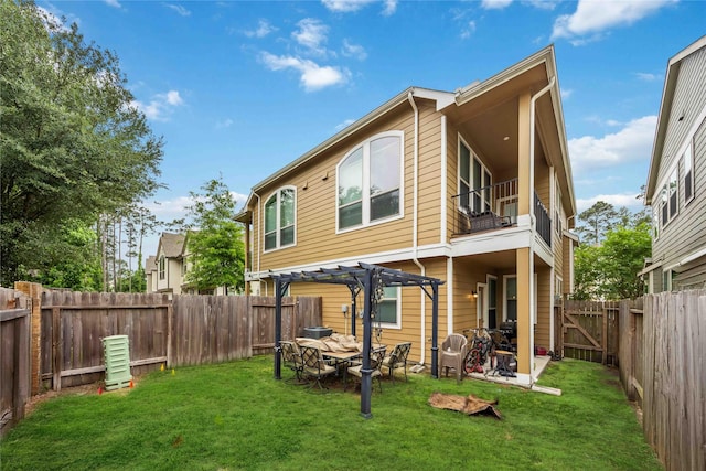rear view of property featuring a pergola, a fenced backyard, a balcony, a yard, and a patio area