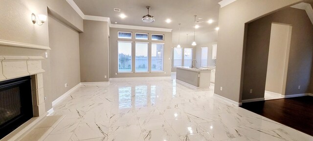 2711 Wollemi Pine Trl, Katy, TX 77493 - unfurnished living room featuring baseboards, a fireplace, marble finish floor, and crown molding