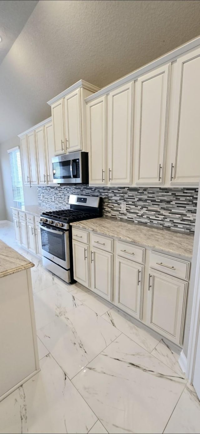 2711 Wollemi Pine Trl, Katy, TX 77493 - kitchen featuring white cabinets, marble finish floor, stainless steel appliances, decorative backsplash, and a textured ceiling