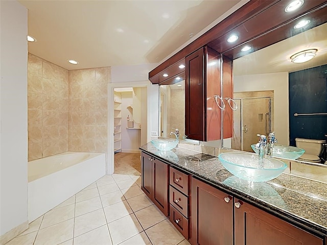 bathroom with double vanity, tile patterned floors, a stall shower, and a sink