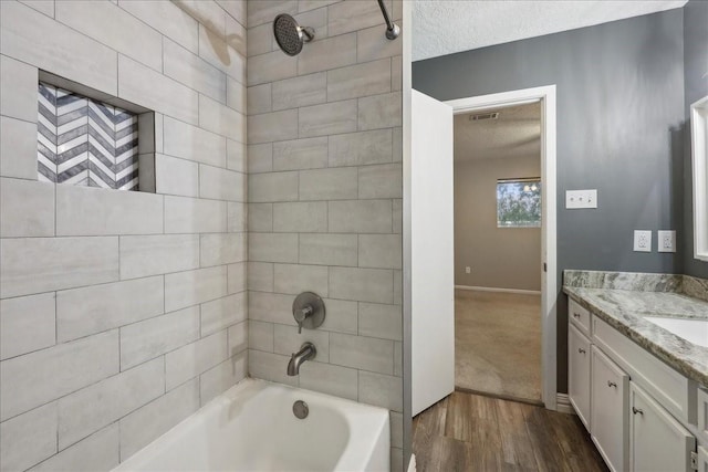 1117 Meadowland Dr, Beaumont, TX 77706 - full bathroom featuring a textured ceiling, baseboards, wood finished floors, washtub / shower combination, and vanity
