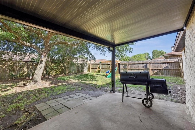 1117 Meadowland Dr, Beaumont, TX 77706 - view of patio / terrace featuring a fenced backyard, a playground, and a grill