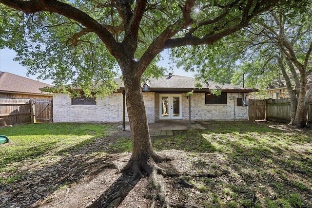 1117 Meadowland Dr, Beaumont, TX 77706 - rear view of property with a gate, a patio, a fenced backyard, and french doors