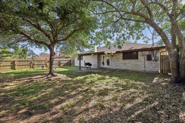 1117 Meadowland Dr, Beaumont, TX 77706 - rear view of house with a fenced backyard, a yard, a patio area, french doors, and brick siding