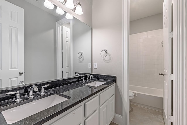 full bath with toilet, tile patterned flooring, a sink, and double vanity