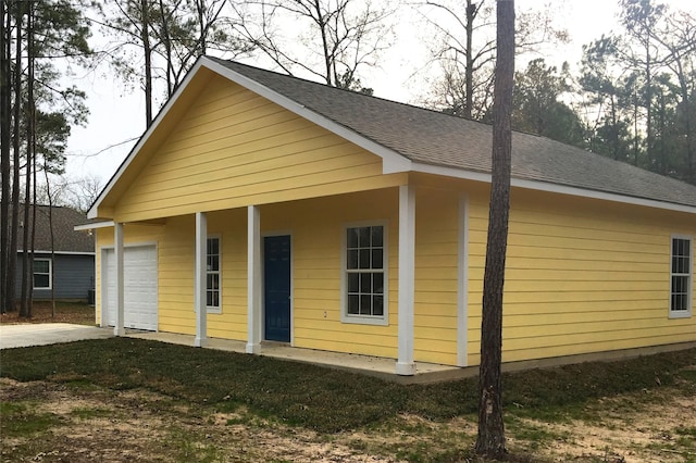 view of front of house featuring driveway and roof with shingles