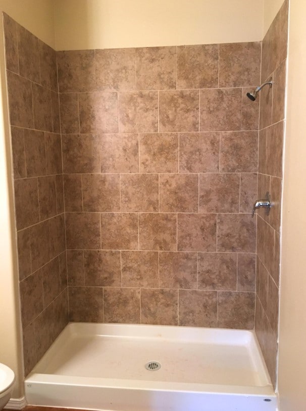 full bathroom featuring toilet and a stall shower