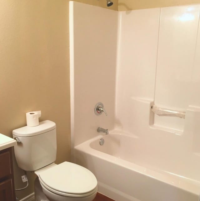 bathroom with toilet, shower / bathtub combination, and vanity