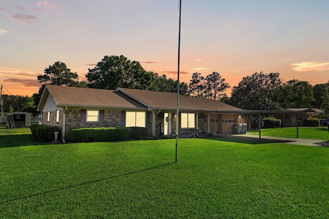 single story home with brick siding, an attached garage, driveway, and a front yard