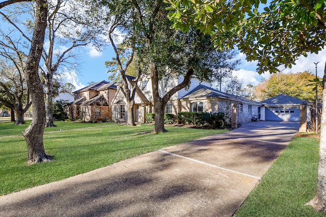 view of front of house featuring driveway, a front yard, and an outbuilding
