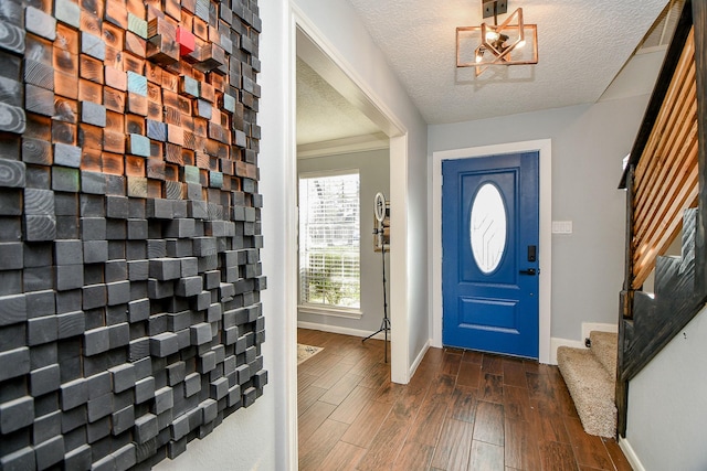 foyer featuring dark wood finished floors, stairway, visible vents, baseboards, and a textured ceiling