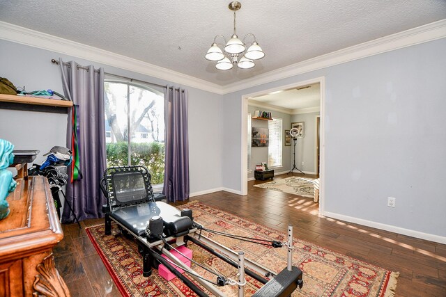 living room featuring a textured ceiling, baseboards, a notable chandelier, crown molding, and wood-type flooring