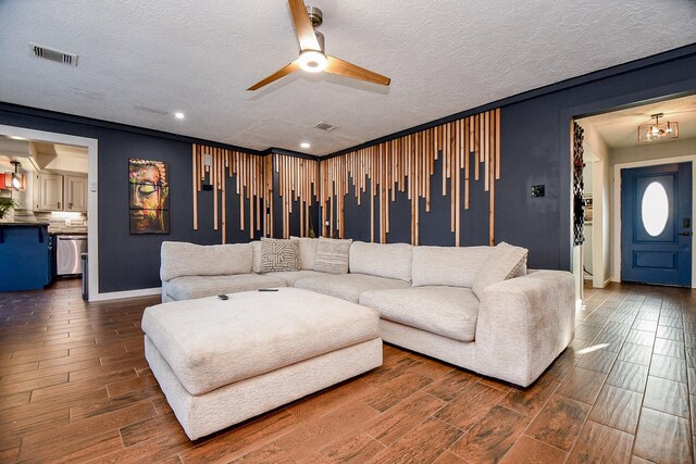 living room with wood tiled floor, a textured ceiling, ceiling fan, and visible vents
