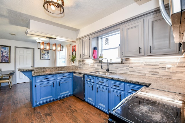 kitchen with a peninsula, stainless steel dishwasher, a sink, and blue cabinetry