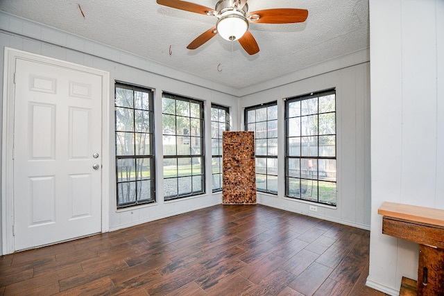 doorway with ceiling fan, wood finished floors, and a textured ceiling