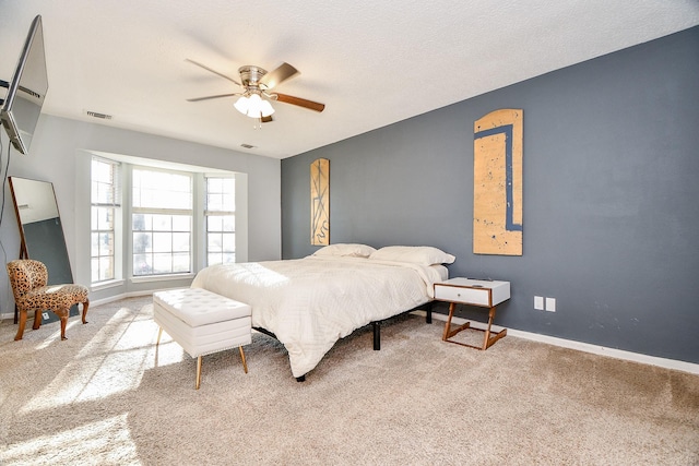 carpeted bedroom with baseboards, visible vents, and ceiling fan