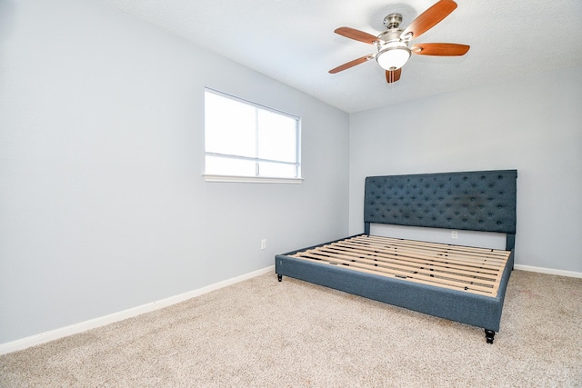 unfurnished bedroom featuring baseboards, a ceiling fan, and carpet flooring