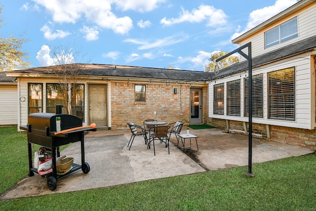 back of property with a lawn, stone siding, and a patio area