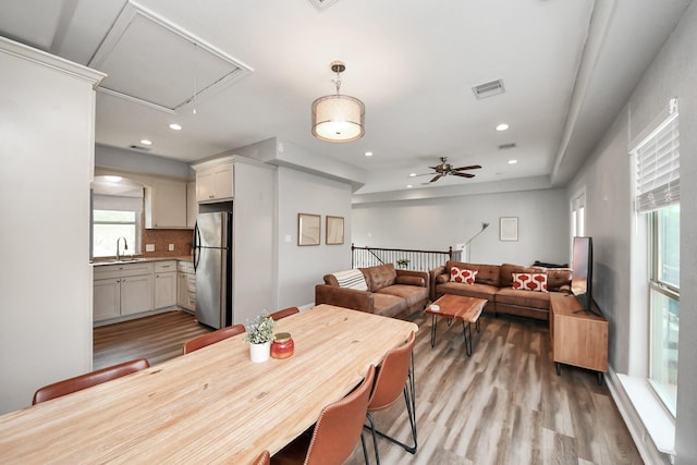 1561 Scharpe St, Houston, TX 77023 - dining area featuring attic access, light wood-style flooring, visible vents, and plenty of natural light