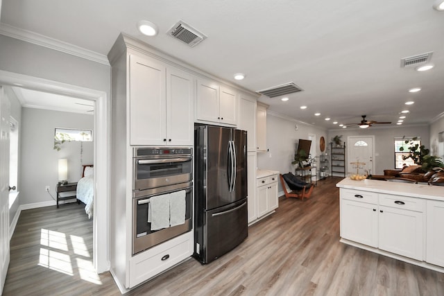 1561 Scharpe St, Houston, TX 77023 - kitchen with double oven, visible vents, freestanding refrigerator, crown molding, and ceiling fan
