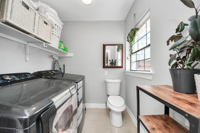 1561 Scharpe St, Houston, TX 77023 - clothes washing area with baseboards, washer and clothes dryer, laundry area, and light tile patterned floors