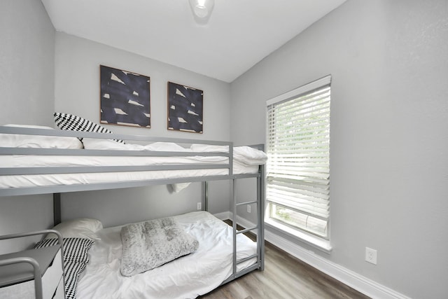 1561 Scharpe St, Houston, TX 77023 - bedroom with vaulted ceiling, baseboards, and wood finished floors