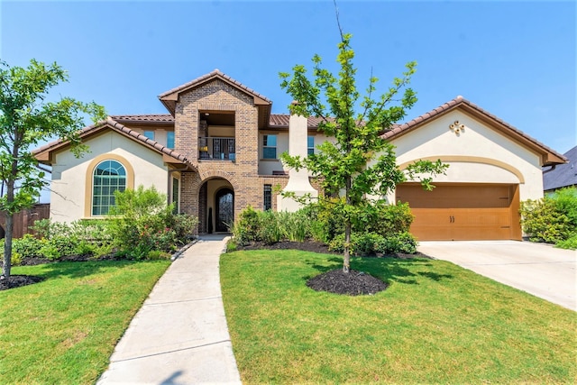 mediterranean / spanish home featuring a garage, driveway, a front yard, and stucco siding