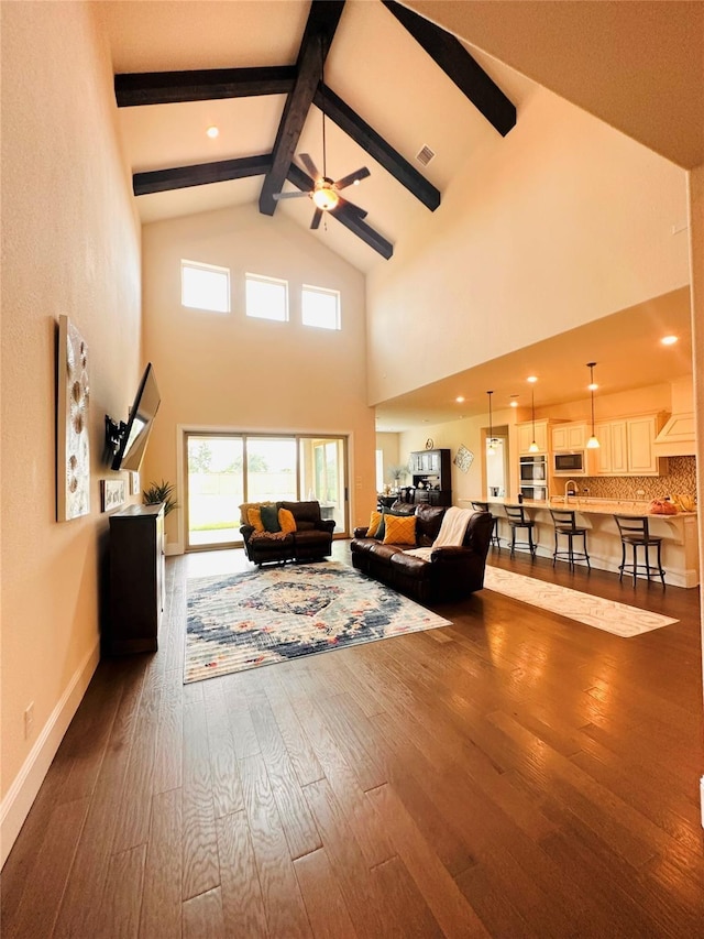 living area featuring beam ceiling, high vaulted ceiling, a ceiling fan, and dark wood-style flooring