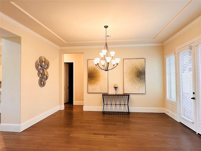unfurnished dining area featuring a chandelier, wood finished floors, crown molding, and baseboards