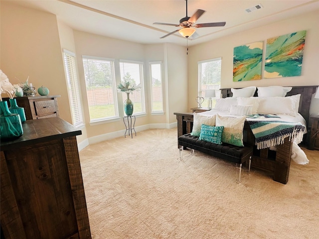 carpeted bedroom with baseboards, a ceiling fan, and visible vents
