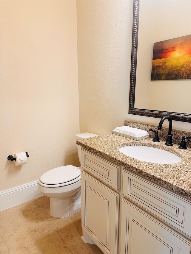 bathroom with tile patterned flooring, baseboards, toilet, and vanity