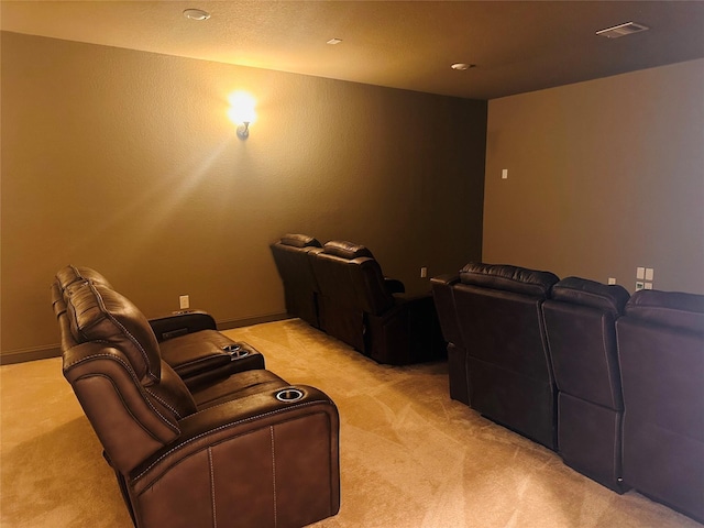 cinema room featuring visible vents and light colored carpet
