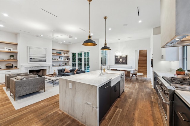 2926 Wroxton Rd, West University Place, TX 77005 - kitchen with wall chimney range hood, appliances with stainless steel finishes, modern cabinets, dark wood-type flooring, and a sink