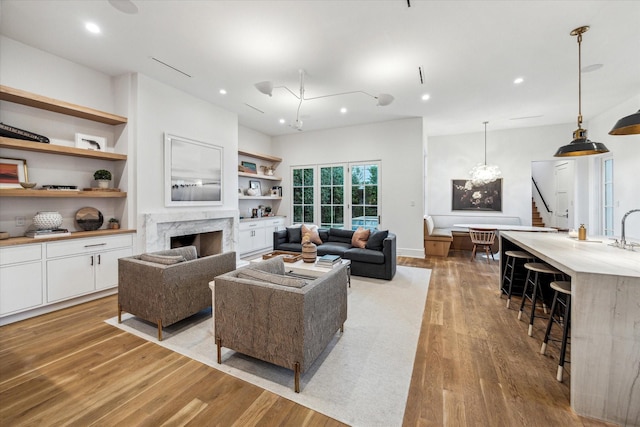 2926 Wroxton Rd, West University Place, TX 77005 - living room featuring light wood-type flooring, stairway, a high end fireplace, recessed lighting, and built in shelves
