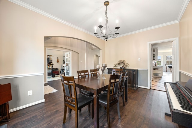 dining area featuring arched walkways, ornamental molding, dark wood-style flooring, and a notable chandelier
