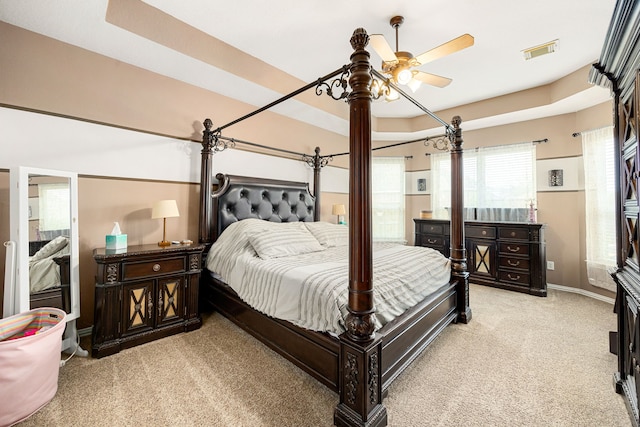 bedroom with light colored carpet, a ceiling fan, baseboards, and visible vents