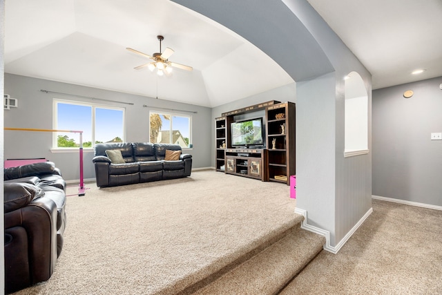 carpeted living area featuring baseboards, ceiling fan, and lofted ceiling