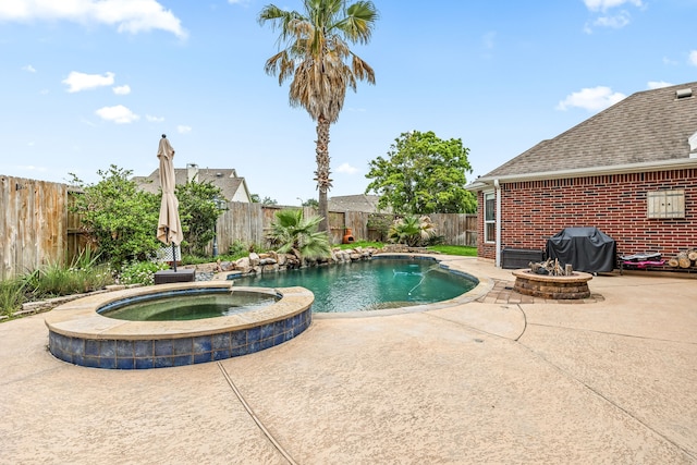 view of pool with a fenced backyard, a pool with connected hot tub, area for grilling, and a patio area