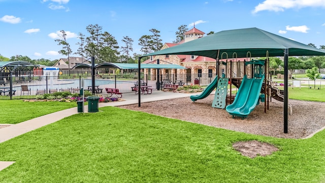 community jungle gym with fence and a yard