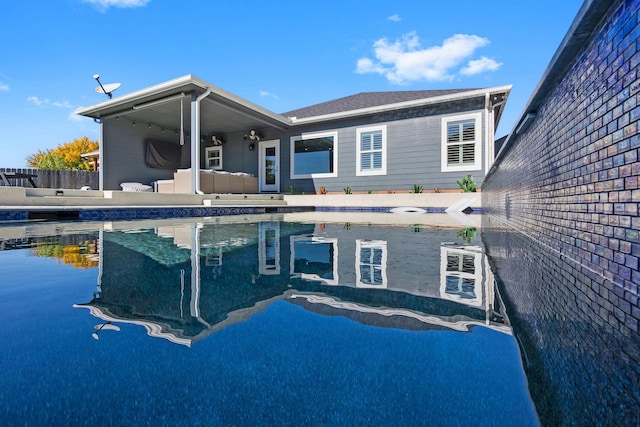 back of house featuring an outdoor pool and fence