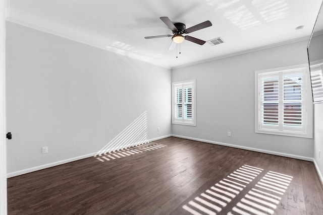 unfurnished room with crown molding, wood finished floors, baseboards, and ceiling fan