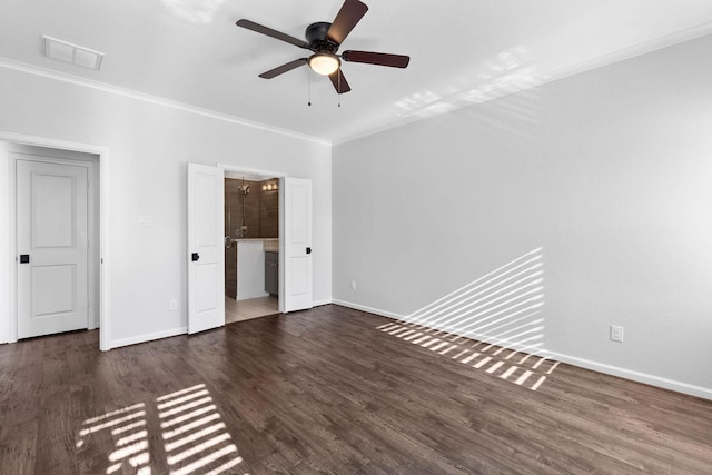 unfurnished bedroom featuring ornamental molding, baseboards, wood finished floors, ensuite bathroom, and a ceiling fan
