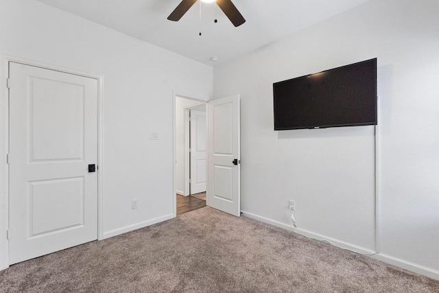 unfurnished bedroom featuring carpet flooring, baseboards, and a ceiling fan