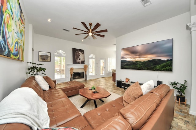 living area with a ceiling fan, visible vents, a glass covered fireplace, and recessed lighting