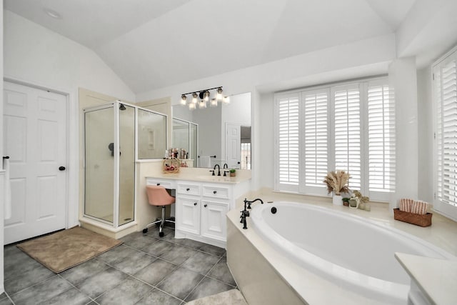 full bathroom featuring vaulted ceiling, a shower stall, a garden tub, and vanity
