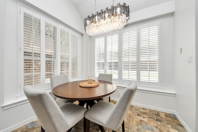 dining area with baseboards, a healthy amount of sunlight, and stone finish floor