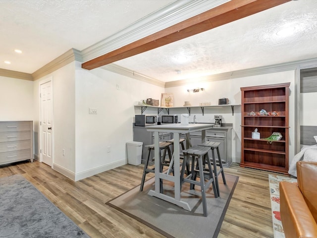 1002 Staples Ave, Seabrook, TX 77586 - dining room with ornamental molding, a textured ceiling, baseboards, and light wood finished floors