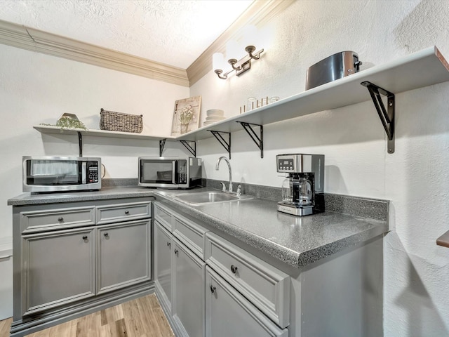 1002 Staples Ave, Seabrook, TX 77586 - kitchen featuring open shelves, stainless steel microwave, gray cabinetry, ornamental molding, and dark countertops