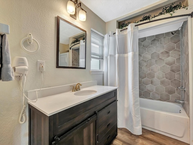 1002 Staples Ave, Seabrook, TX 77586 - full bathroom with wood finished floors, a textured wall, shower / bath combo with shower curtain, and vanity